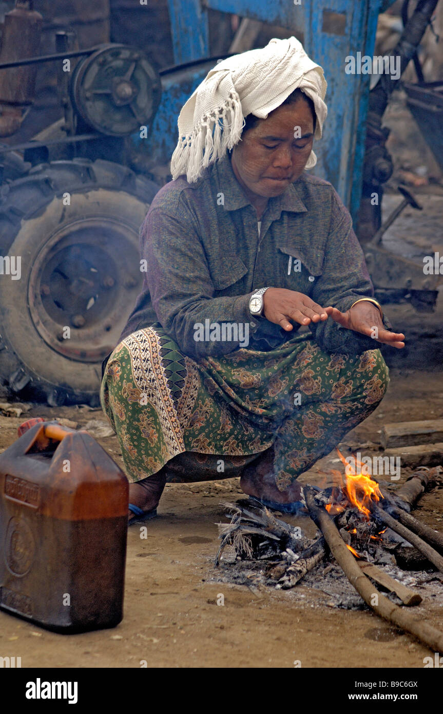 Burmesische Tagelöhner sitzt auf dem kleinen Feuer auf der Fähre von Mandalay Myanmar Stockfoto