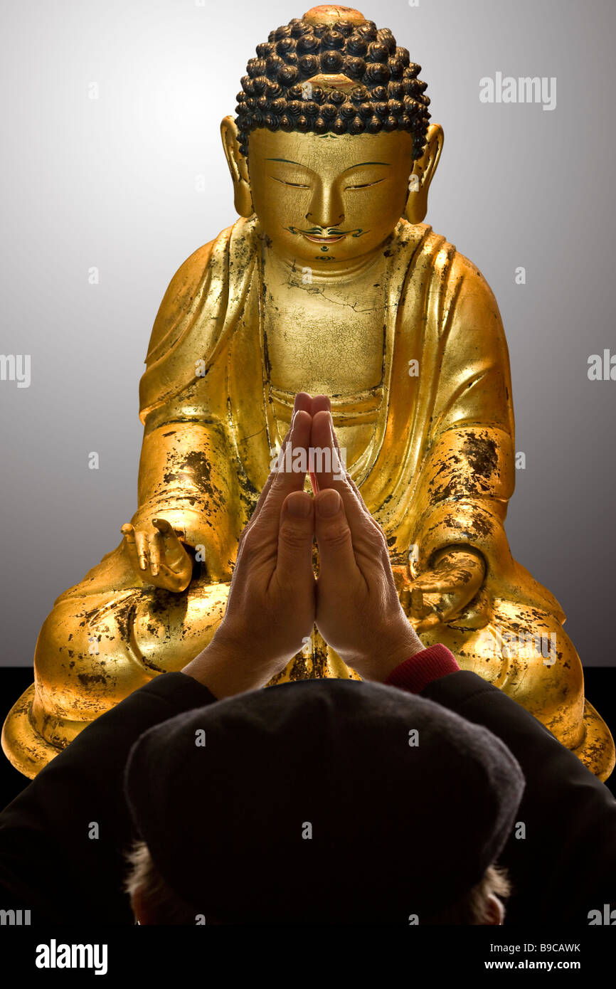 Mann, der betet vor einer Buddha-Figur Stockfoto