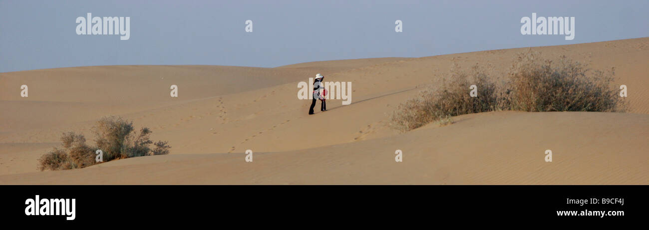 Frau Tourist geht unter den Khuri Sanddünen in der Thar Wüste westlich von Jaisalmer in Rajasthan in Indien Stockfoto