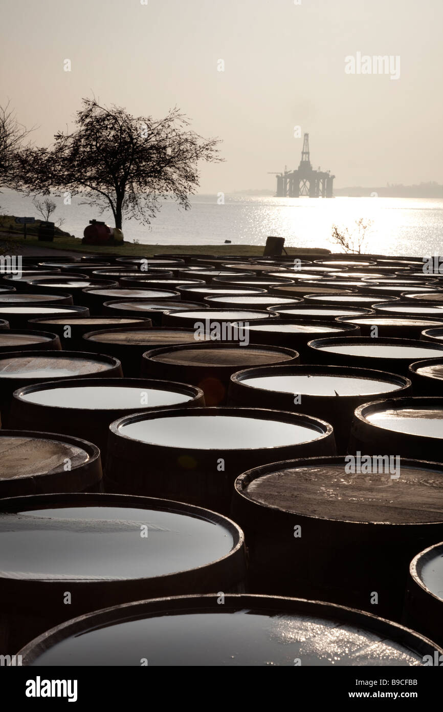 Schottische Ölindustrie Bohranlage im Hafen & Scotch Whisky Fässer Dalmore große Brennerei, Invergordon, Cromarty Firth im Norden von Schottland, Großbritannien. Stockfoto