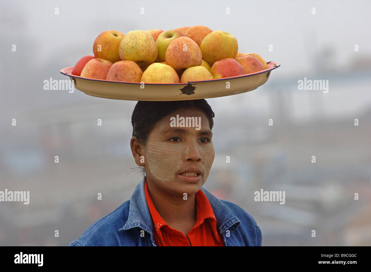 Frau trägt Früchte auf dem Kopf auf dem Markt Mandalay Myanmar Stockfoto