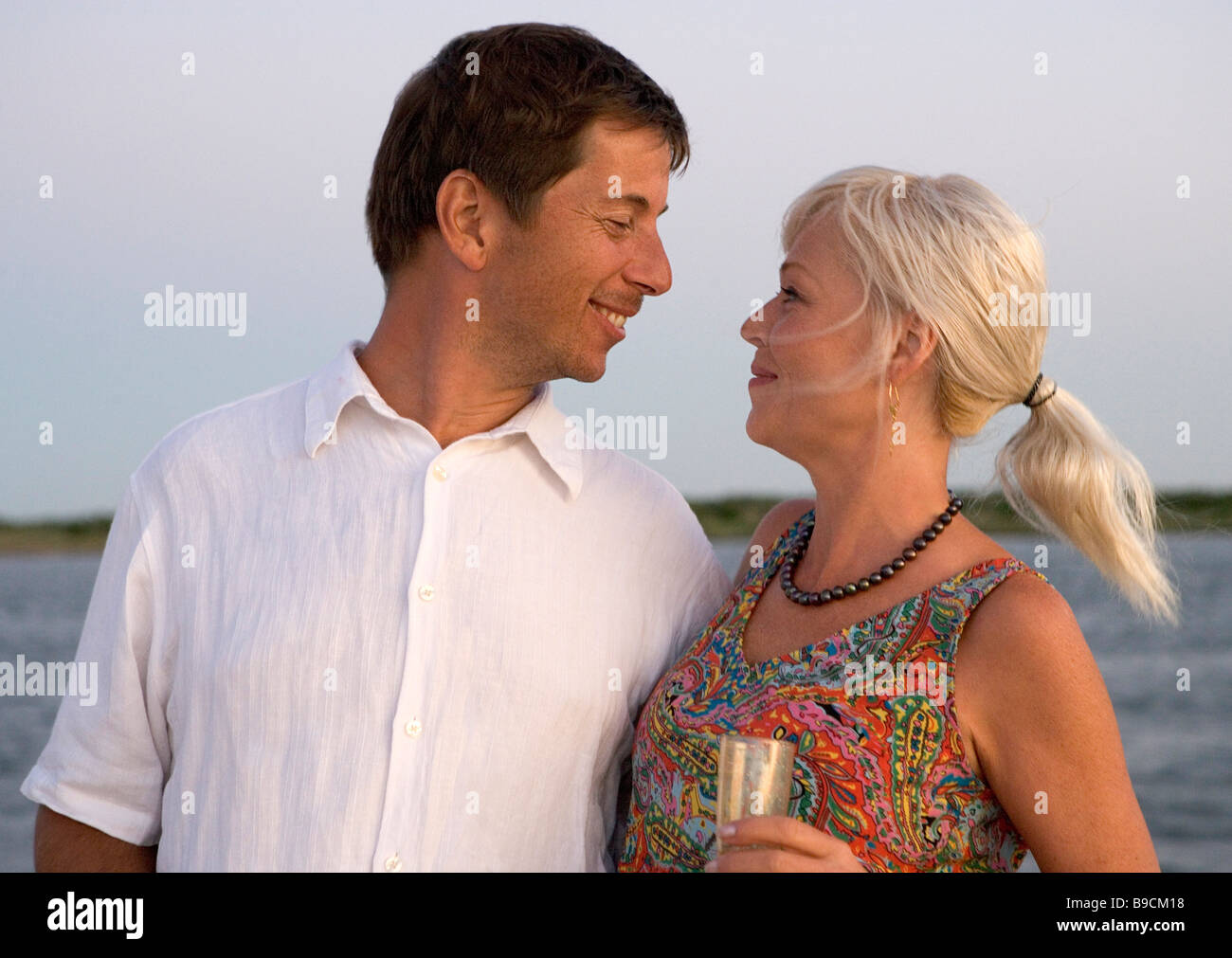 Ein verheiratetes Paar teilen einen intimen Moment an Bord eines Bootes Tour bei Sonnenuntergang Stockfoto