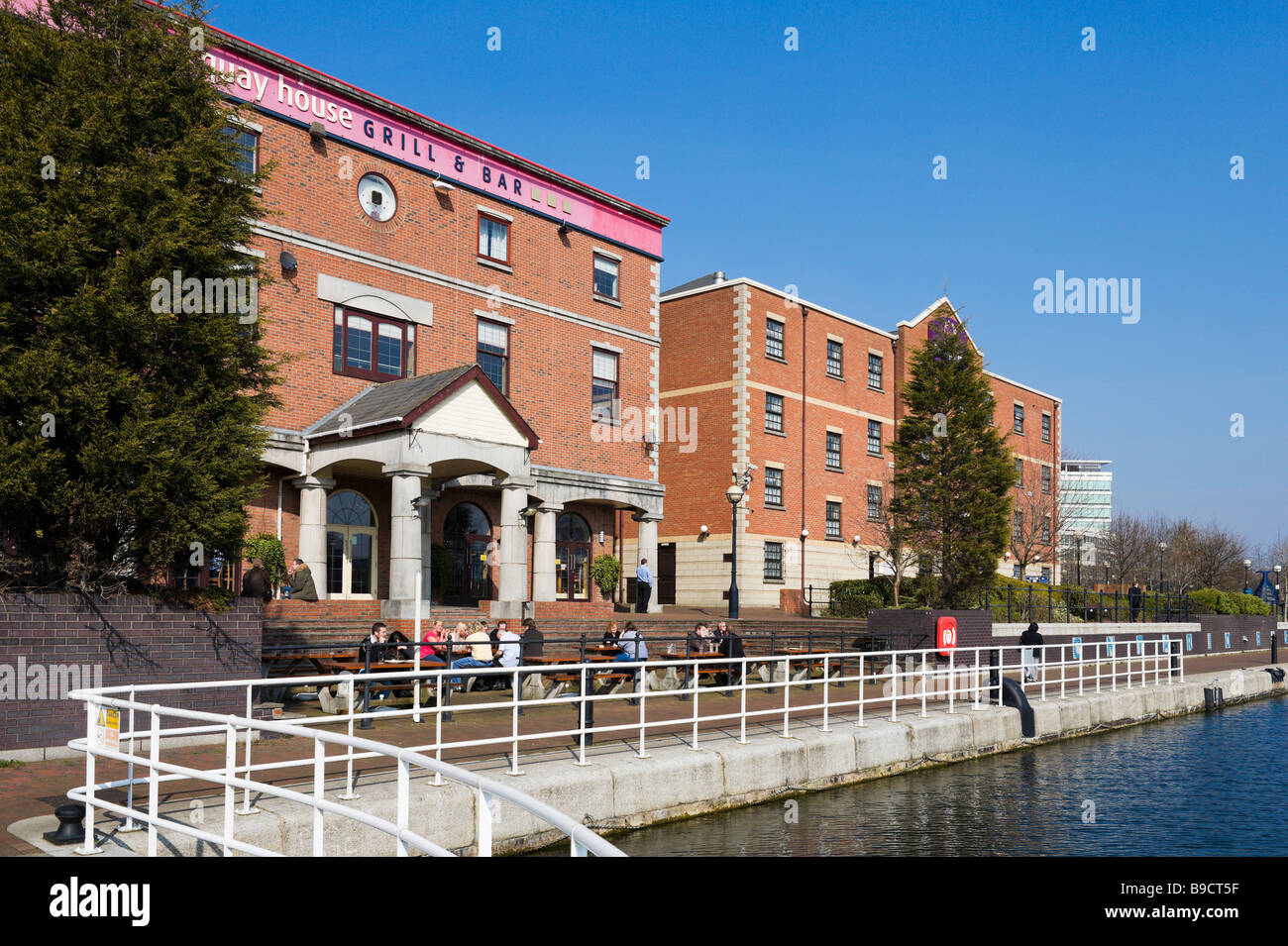 Kunden sitzen außerhalb der Quay House Grill und Bar auf der Ontario-Becken, Salford Quays, Greater Manchester, England Stockfoto