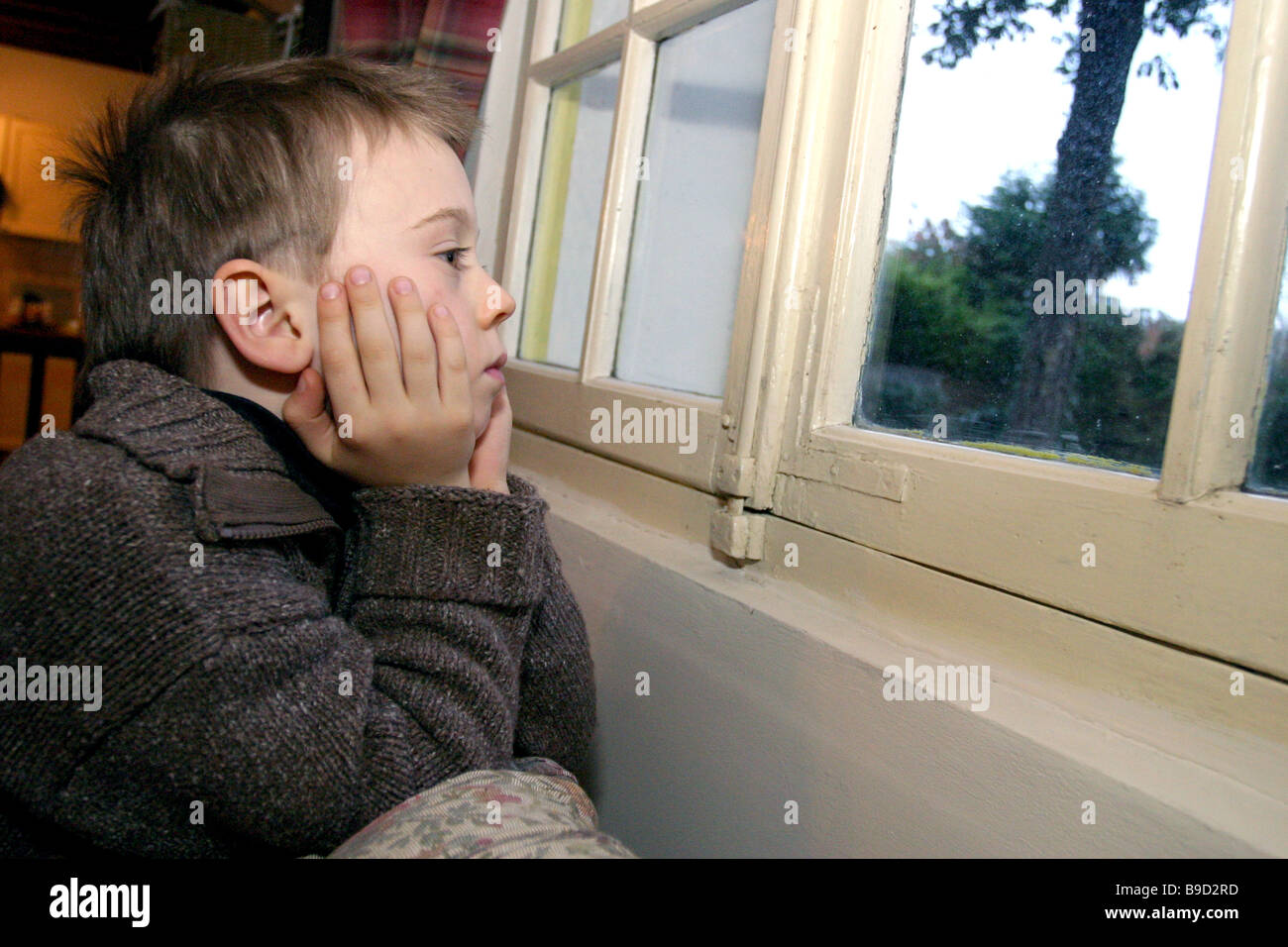 Junges Kind leider Blick aus dem Fenster Stockfoto