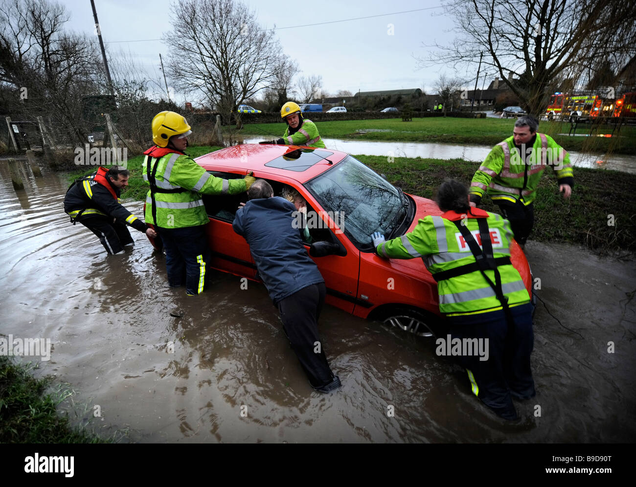 FEUERWEHRMANN RETTEN EINE WEIBLICHEN AUTOFAHRER ERWISCHT DURCH HOCHWASSER IM DORF CRUDWELL IN DER NÄHE VON MALMESBURY GLOUCESTERSHIRE UK JAN 2008 Stockfoto