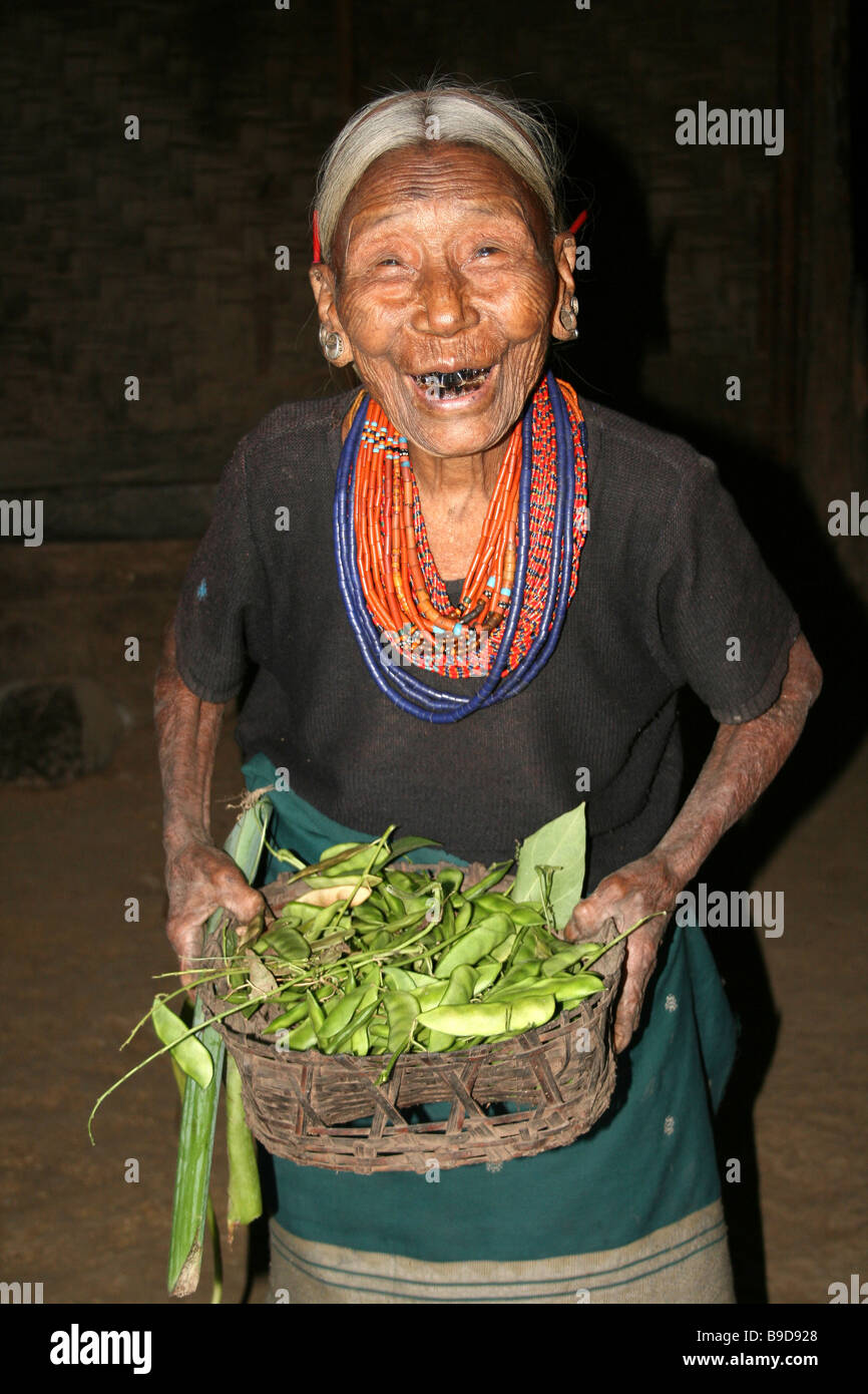 Konyak Naga Stamm Frau lachend und hält Korb mit grünen Bohnen Stockfoto