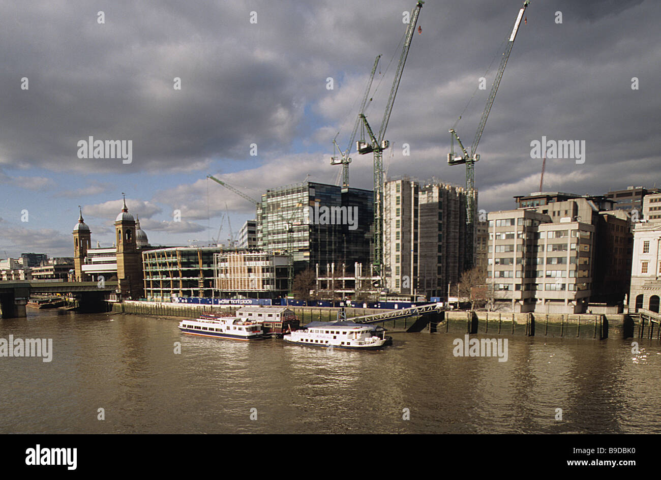 Ansicht der Stadt von London Thames Fassade zwischen Bahnhof Cannon Street und London Bridge, unter Gewitterhimmel. Stockfoto