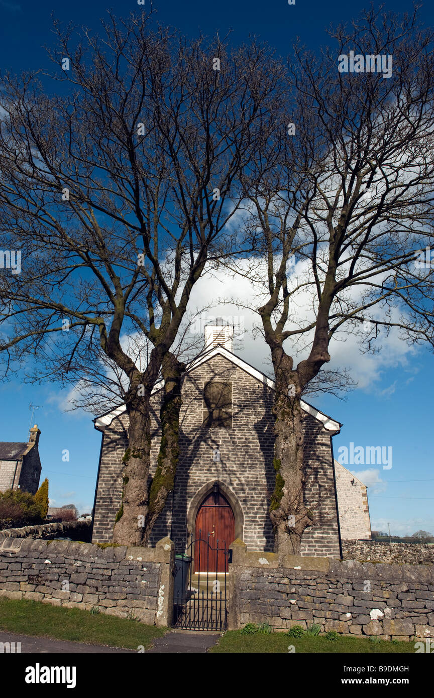 Zwei große Bäume gepflanzt, nah an der Spitze der ehemaligen Unitarian Kirche Flagg, "Peak District", Derbyshire, England, Stockfoto