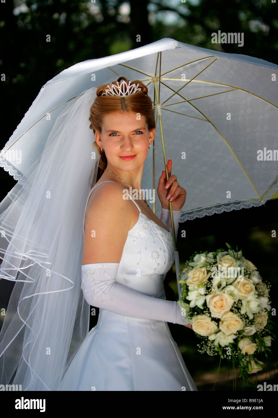 Halben Körper Porträt des Lächelns Braut Holding Bouquet unter Sonnenschirm Stockfoto