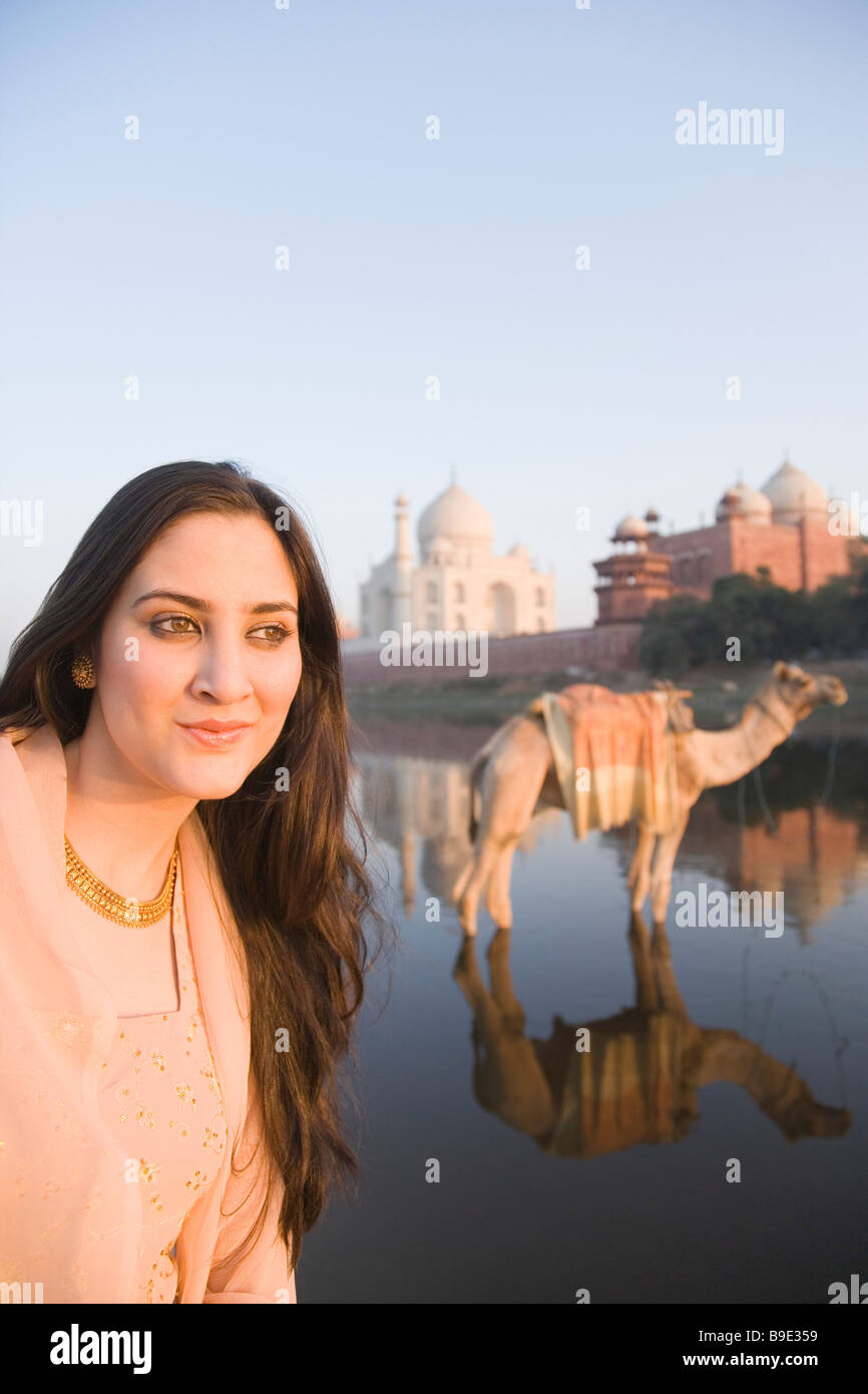 Frau mit einem Kamel und ein Mausoleum im Hintergrund, Taj Mahal, Fluss Yamuna, Agra, Uttar Pradesh, Indien Stockfoto
