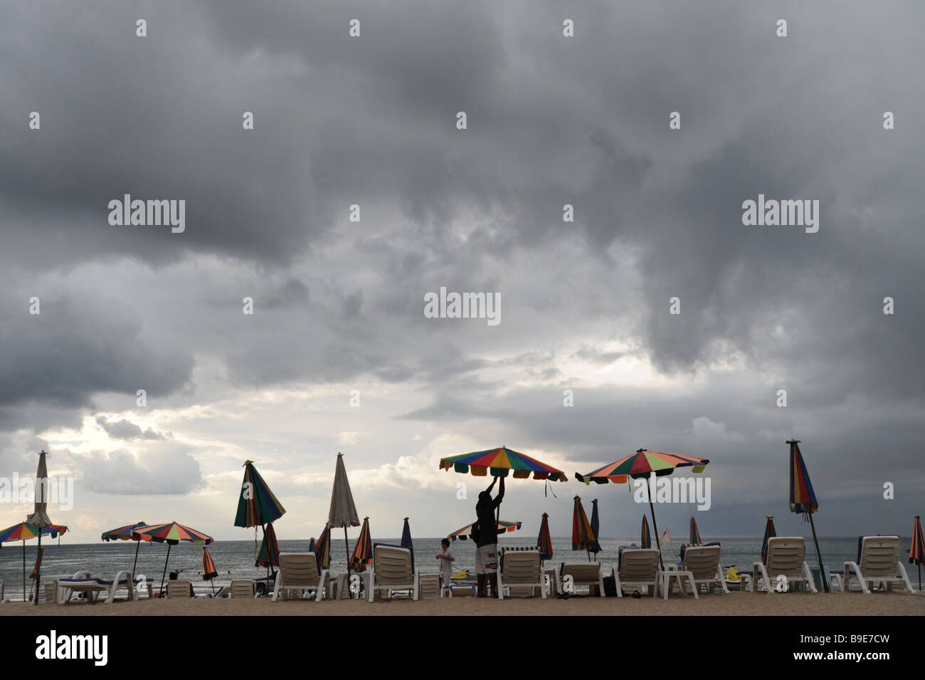 Zeile der Badetücher am Kamala Beach in Phuket Thailand unter einem bedrohlichen Himmel Stockfoto