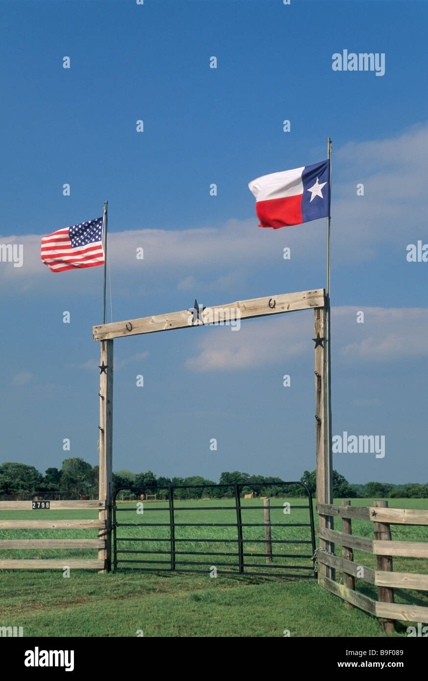 Holz-Ranch-Tor mit TX und USA Flaggen auf TX 90 Autobahn in der Nähe von Anderson in Grimes County Texas USA Stockfoto