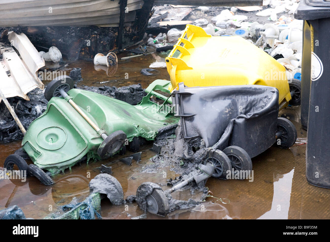 Geschmolzene Wheelie-Kästen und Kunststoff Inhalt nach Brandstiftung Brand Stockfoto