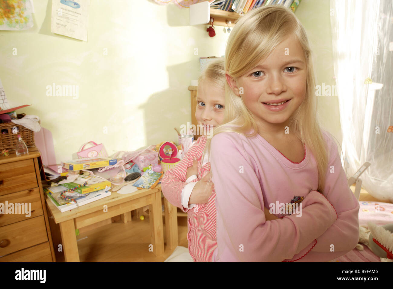 Kindergarten Mädchen zwei Stände Arme kreuzen lächelnd Reihe Detail Menschen Kinder blond Geschwister Schwestern Streit Konfrontation Stockfoto