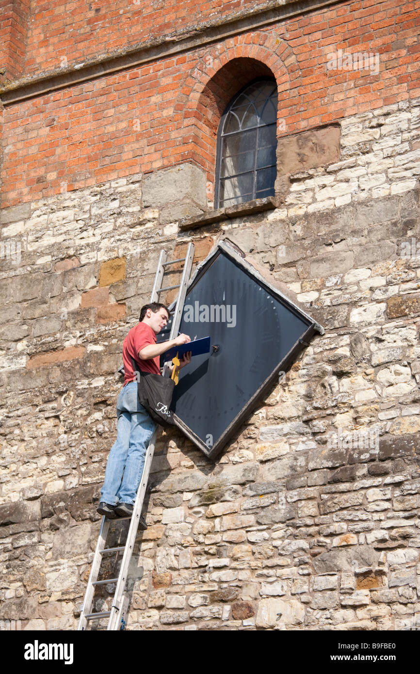 Mann auf Leiter Prüfung eine Turmuhr. Model-Release möglicherweise auf Anfrage erhältlich. Stockfoto