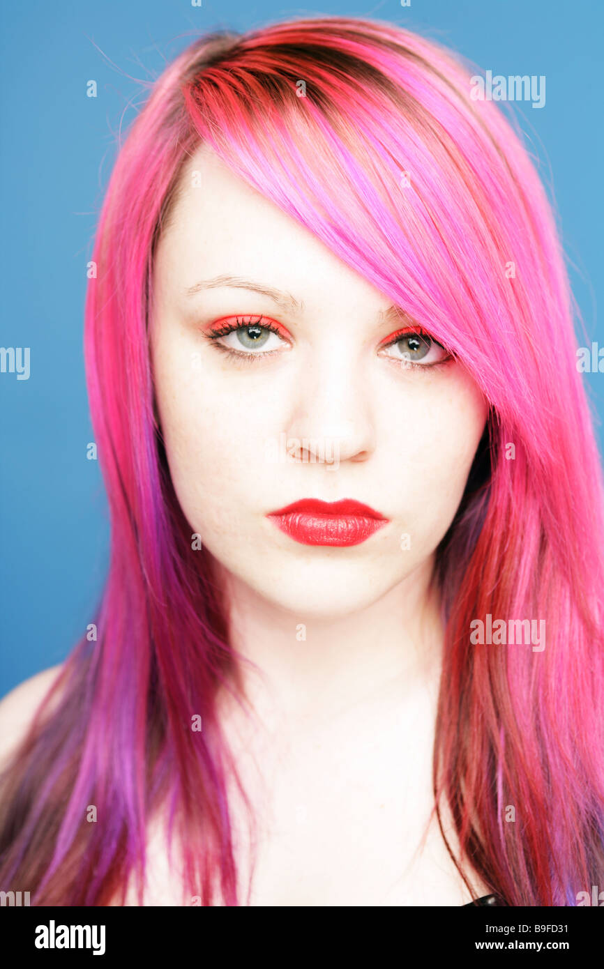 Junge Teen mit leuchtend rosa Haaren und roten Lippen Blick direkt in die Kamera Stockfoto