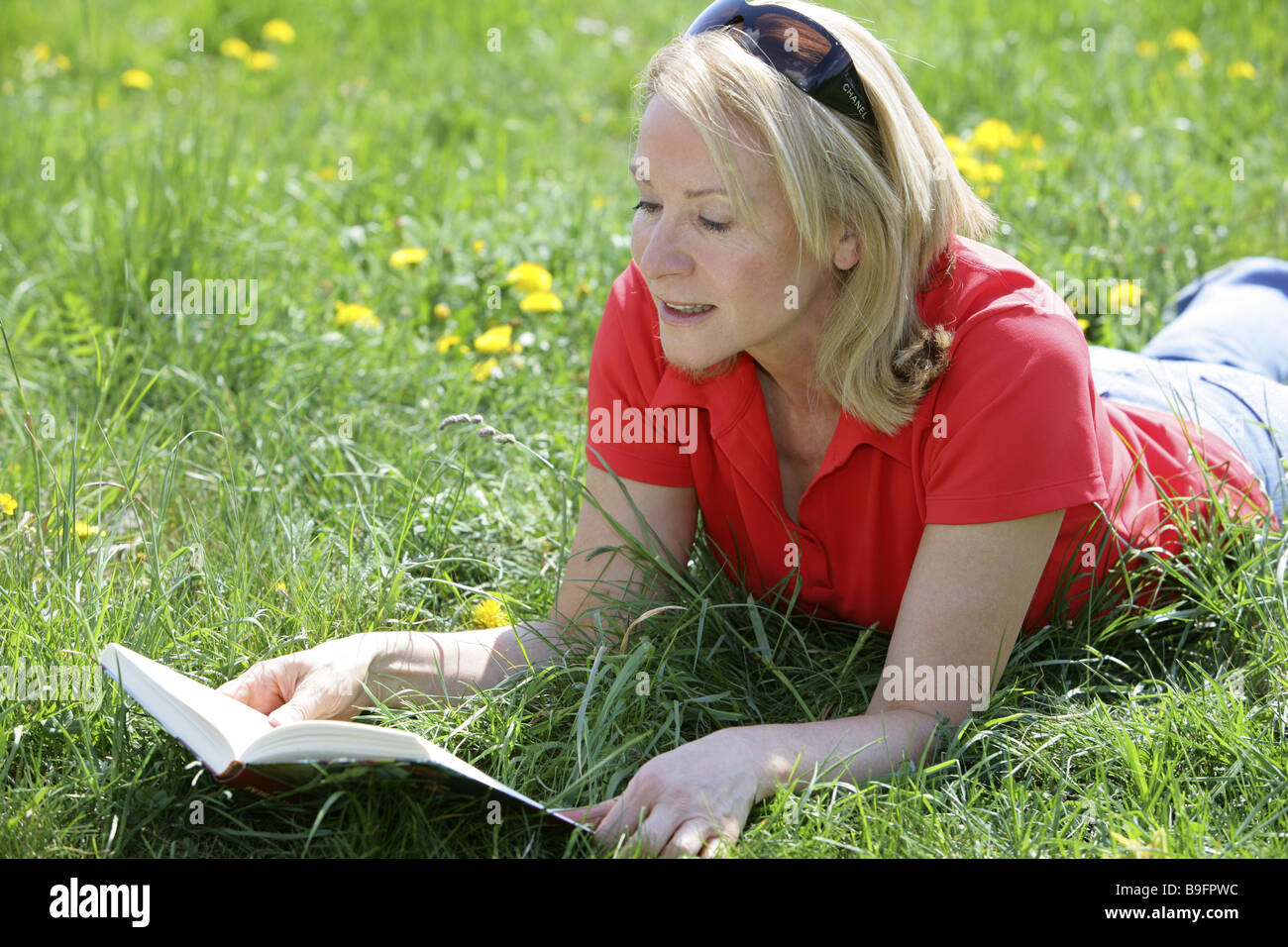 Senior blond Garten entspannen Buch jung geblieben liest 50-60 Jahre 55-65 Jahren 60-70 Jahre attraktiv entsperrt Gleichgewicht Stockfoto