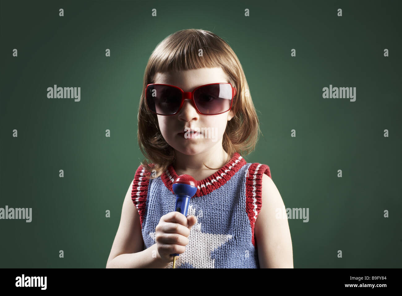 Kind Mädchen singen ernst 5-7 Jahre Sonne Glas Mikrofon Porträt Mädchen dunkel-Blond Brille glücklich konzentriert sich mit Stolz Stockfoto