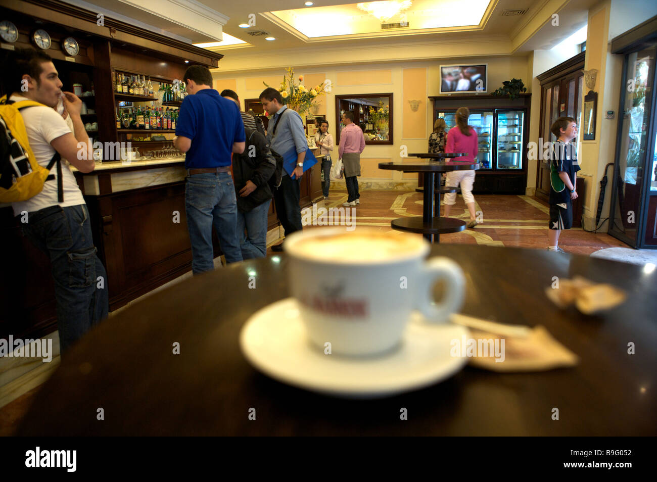 Ein Coffee-Shop in Siena mit einer Tasse Kaffee im Vordergrund und Menschen im Hintergrund Stockfoto