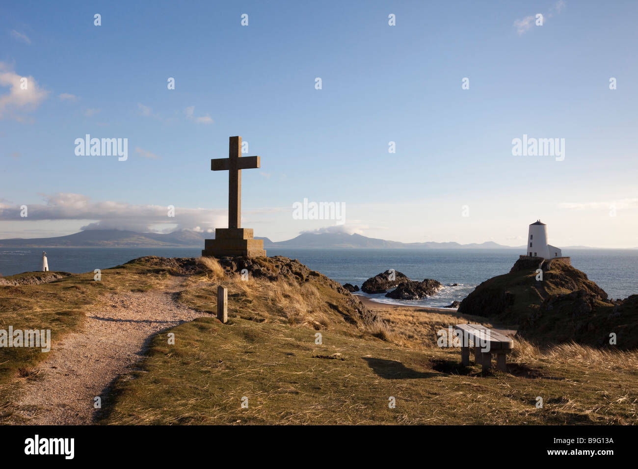 Steinkreuz Memorial und alten Leuchtturm Twr Mawr auf Punkt Ynys Llanddwyn Island in AONB auf Isle of Anglesey North Wales UK Stockfoto