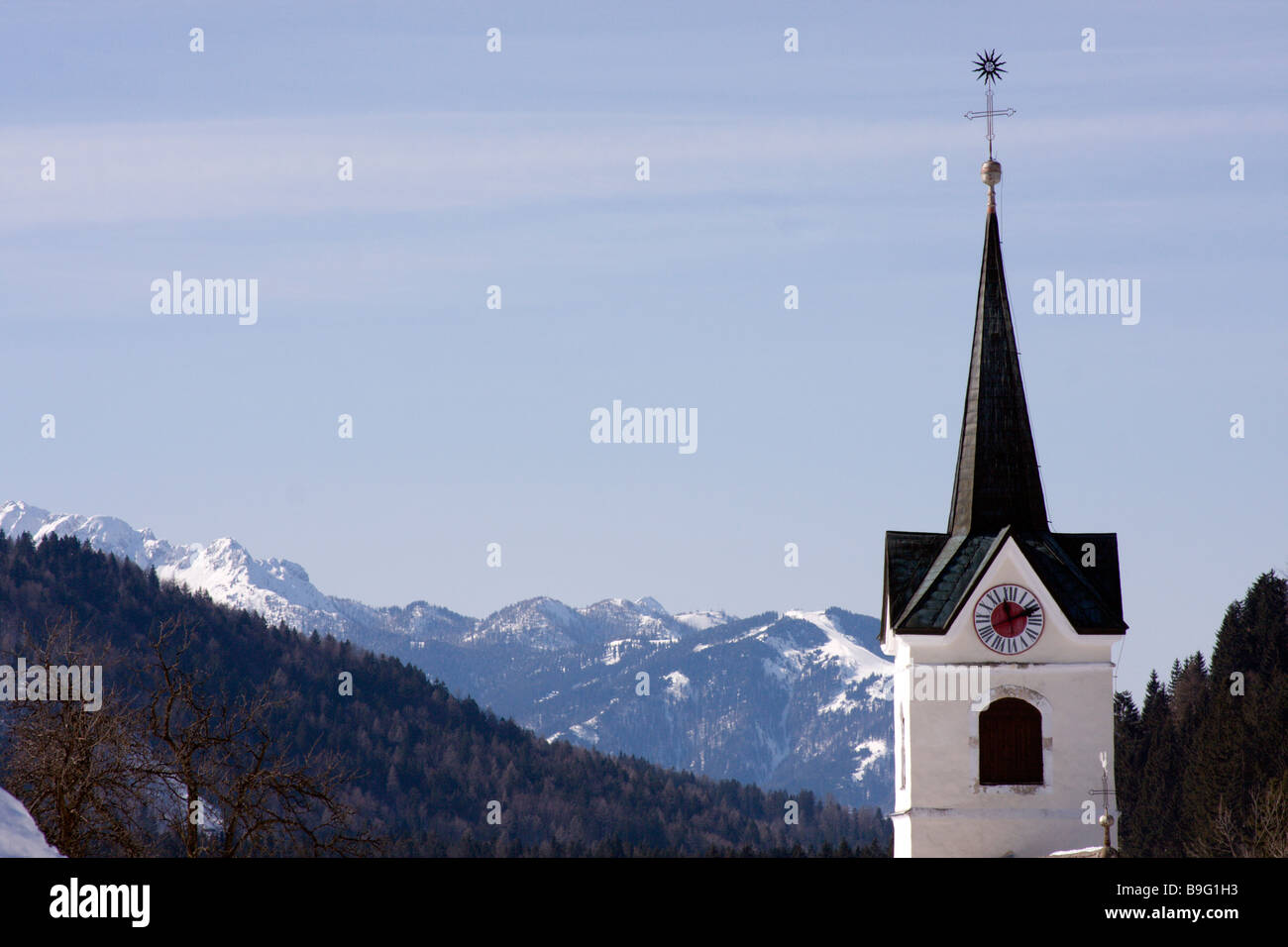 Kirchturm mit Bergen im Hintergrund. Stockfoto