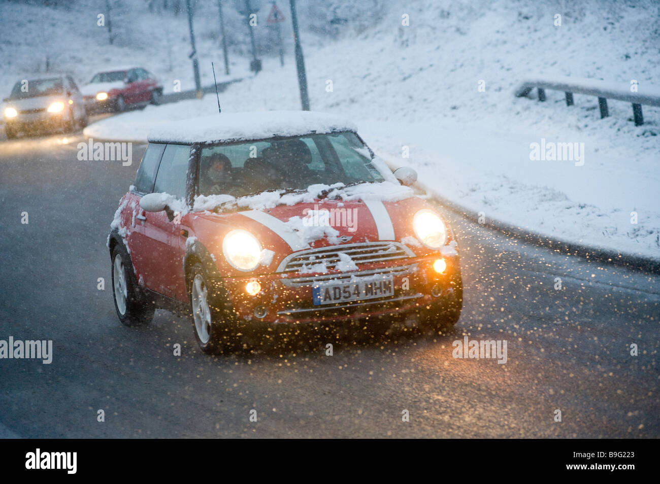 Rote Mini Auto getrieben im verschneiten Wetter an einem Wintertag in england Stockfoto