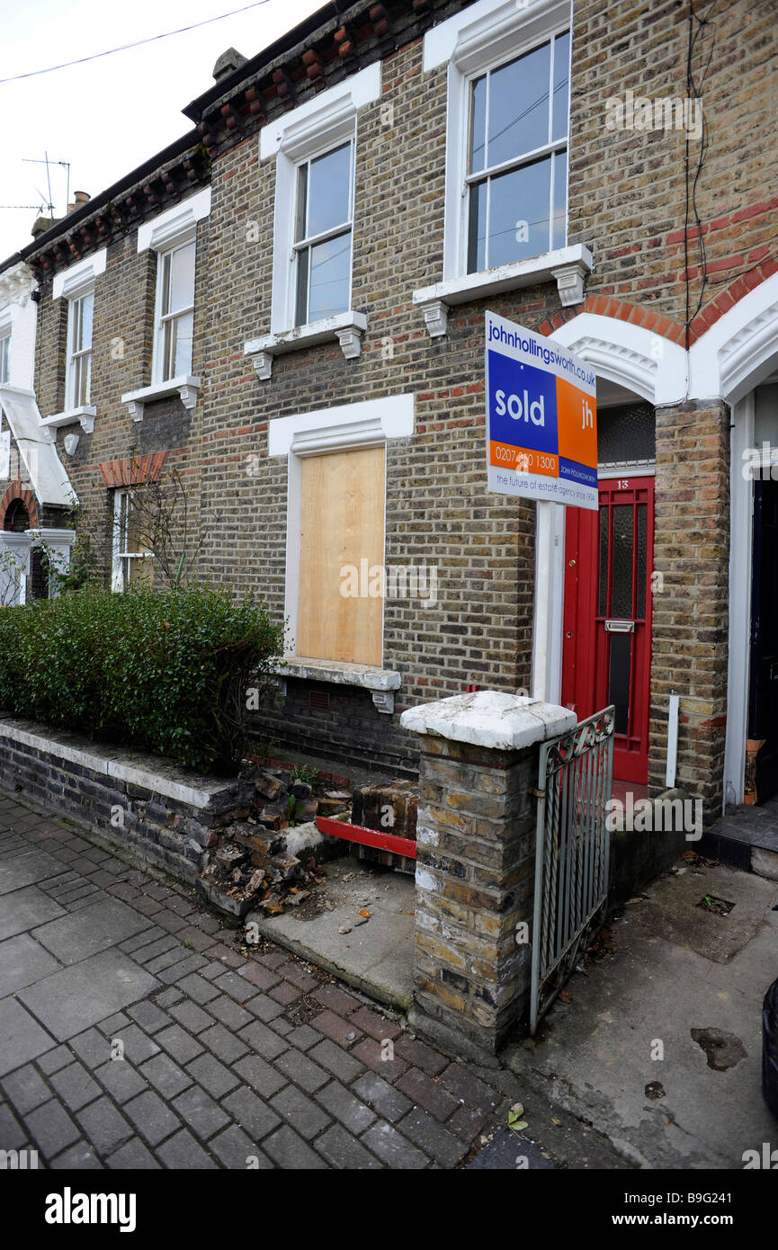 Verkauften Zeichen steht vor einer leer, möglicherweise repossessed, flach, Maisonette mit verschalten Windows in London Stockfoto