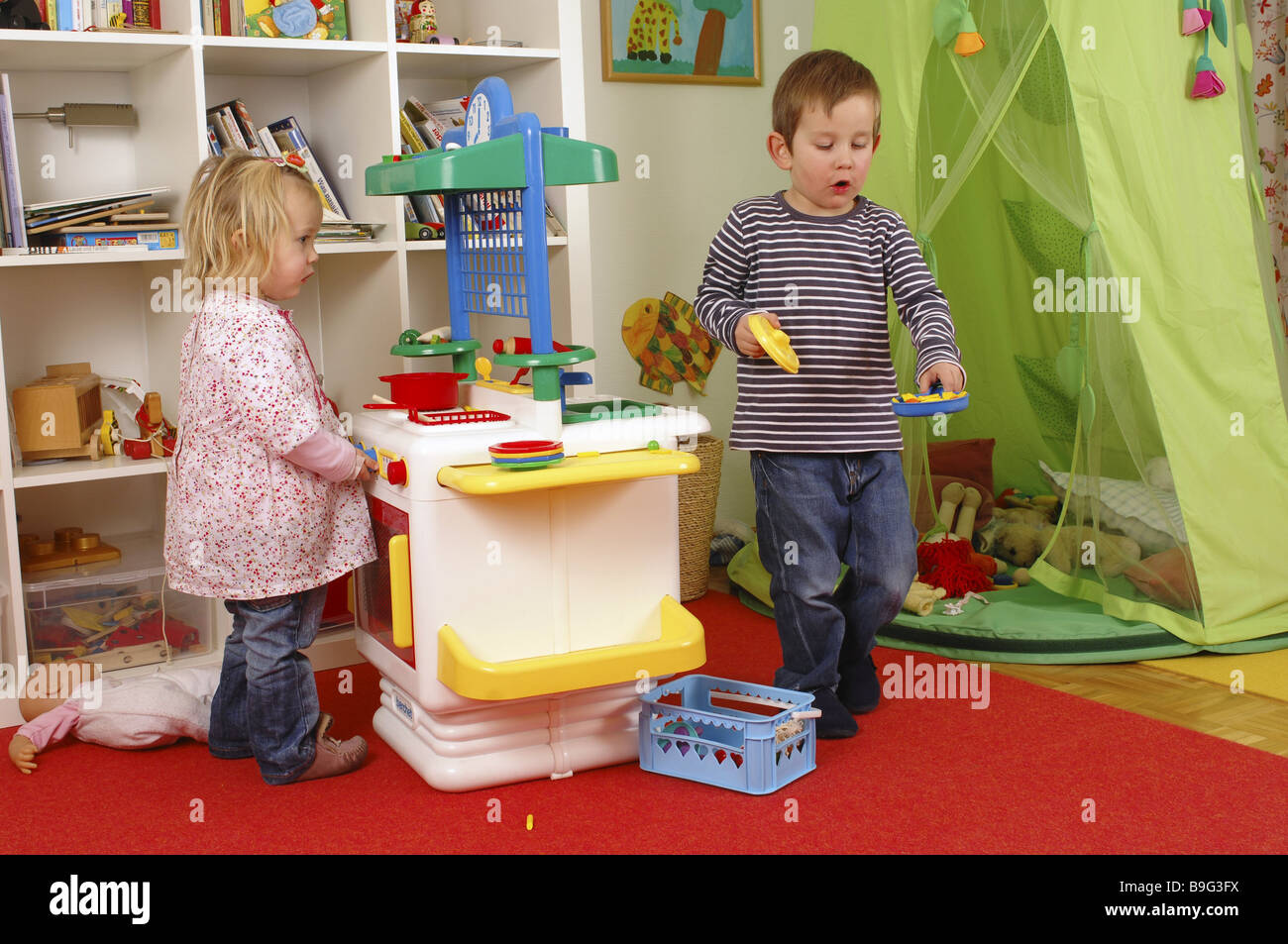 Kinderzimmer junge Mädchen Spielzeug-spielen zusammen Küchenserie Menschen  Kinder zwei Geschwister Bruder Schwester Kunststoff-Herd Spielzeug-Küche  Stockfotografie - Alamy