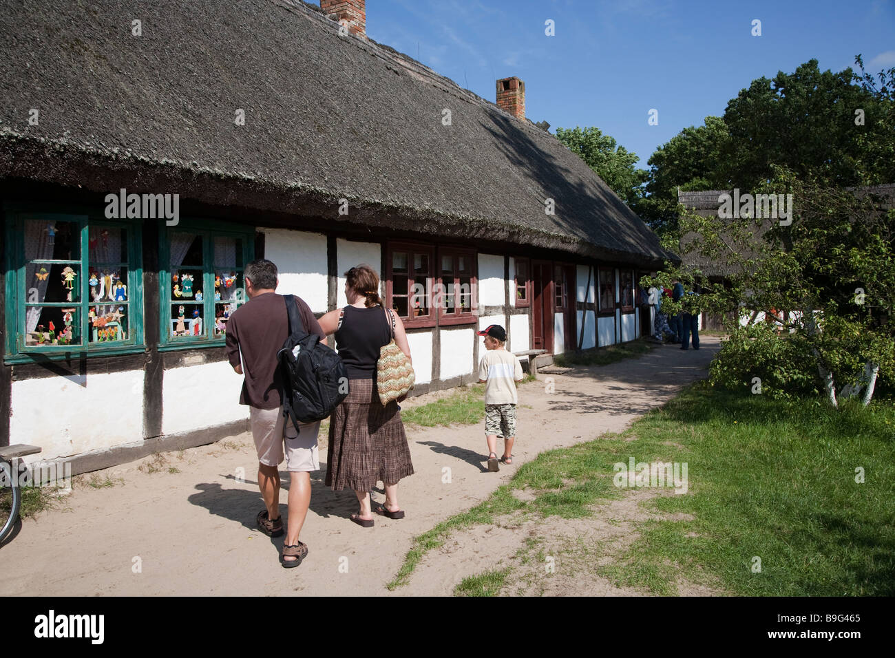 Menschen suchen im Fenster des reetgedeckten Gebäude im Heimatmuseum Stolper Polen Stockfoto