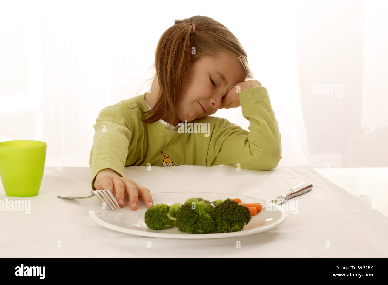 6-8 Jahre Übel Tasse Besteck Brokkoli Brünette Ekel Ernährung essen Gemüse Ausdruck gesunden grünen inneren Kind Stockfoto