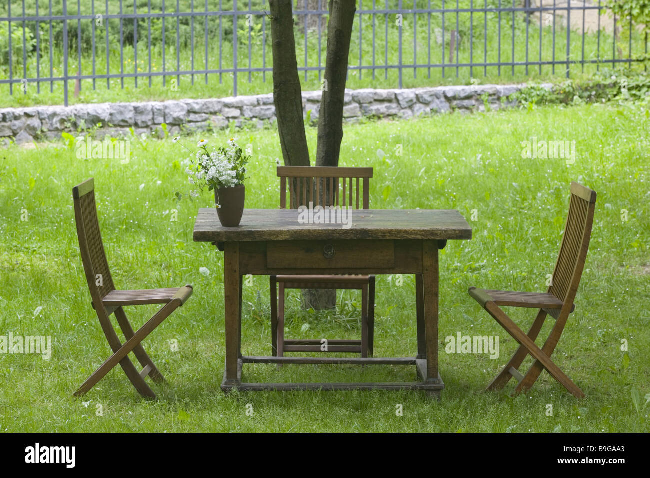 Slowenien Region Primorska Gartentisch Vase Stühle Bäume Sommer Spodnja Idrija Wiese Zaun Zaun-Gartenmöbel Stockfoto