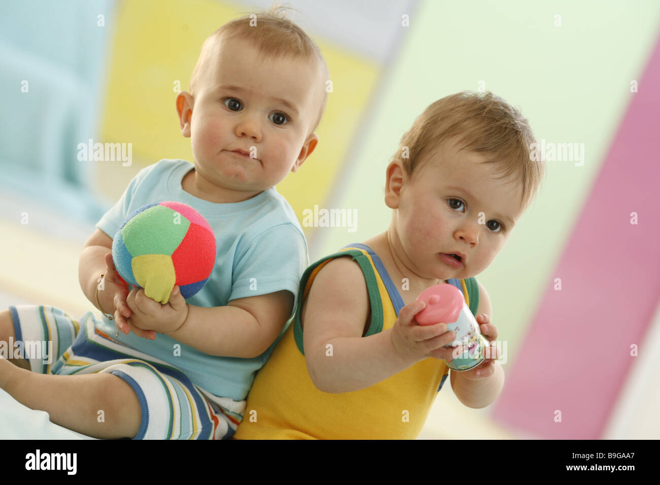 Babys sitzen nebeneinander Freunde Spielzeug in voller Länge 10 Monate geweckt Mitmusiker Baby-Ball-Babyrassel Babys Baby-Spielzeug-ball Stockfoto