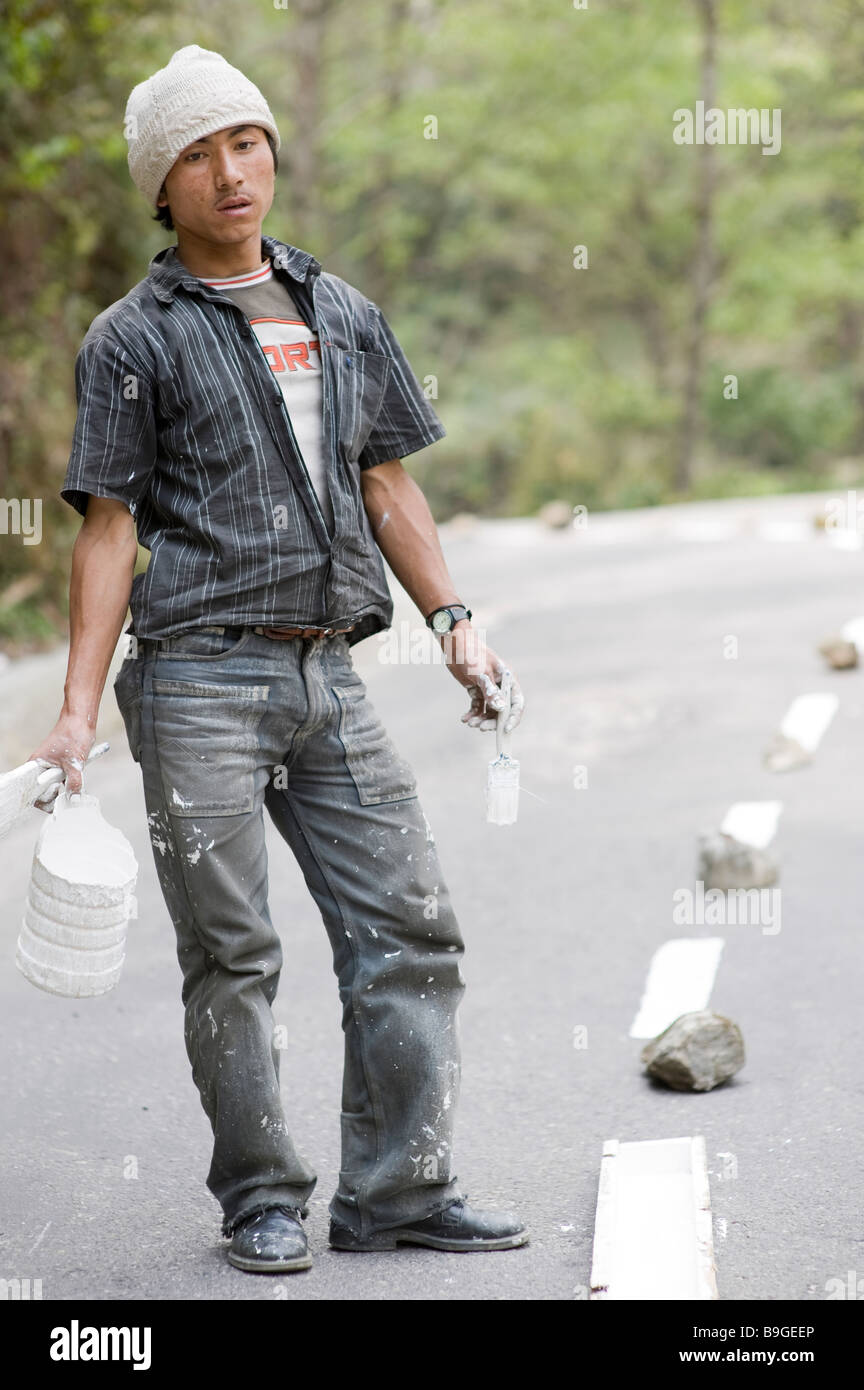 Junger Mann Roadworker Gemälde weiße Linien auf einer Straße in Bhutan Stockfoto