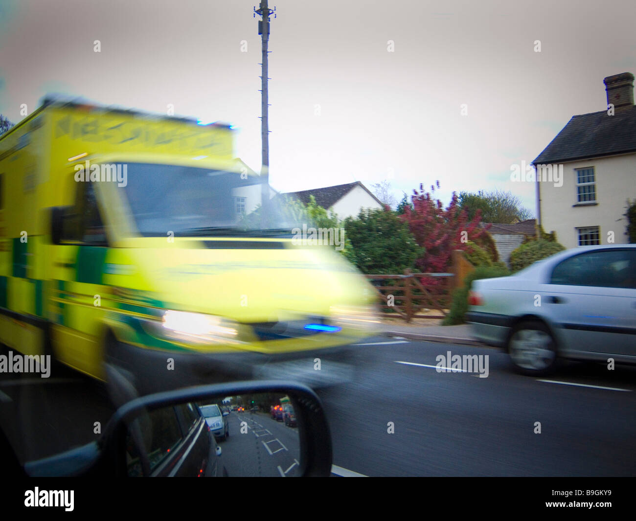 Ein Krankenwagen in Bewegung eilt vorbei zu einem Notfall Stockfoto