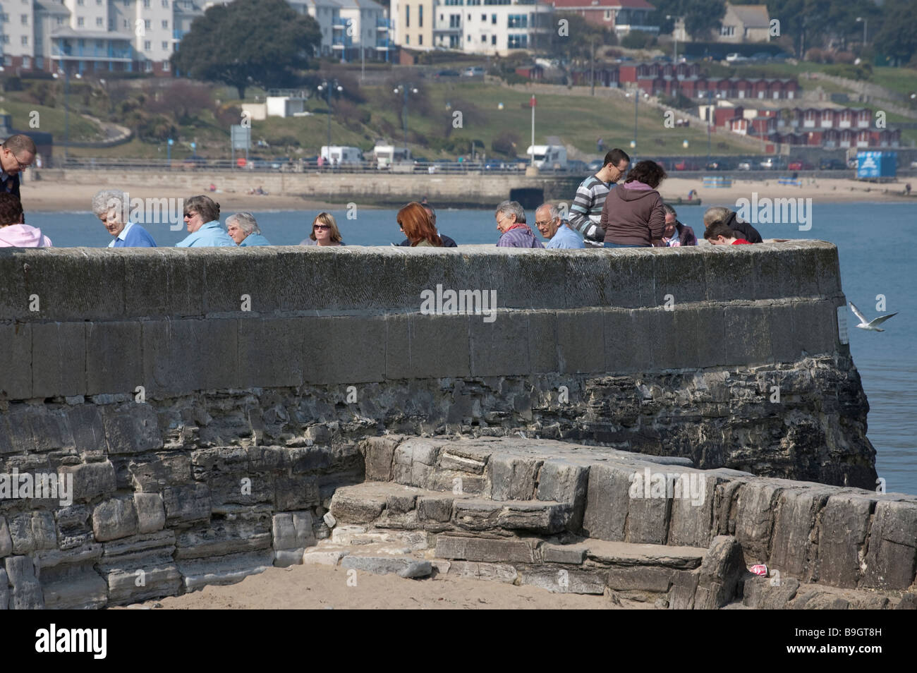 Sitzen auf dem Deich am Meer Stockfoto