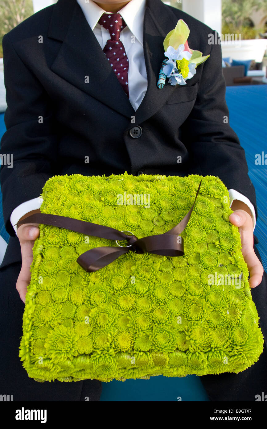 Ringträger hält Chartreuse Blume Ringkissen vor der Zeremonie Stockfoto