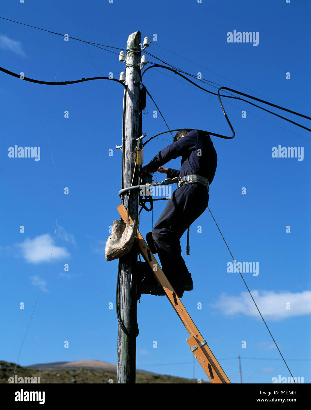 Telefonmast auf einen irischen ländlichen Straße mit Oberleitungen von einem Telekom-Techniker, Irland Stockfoto
