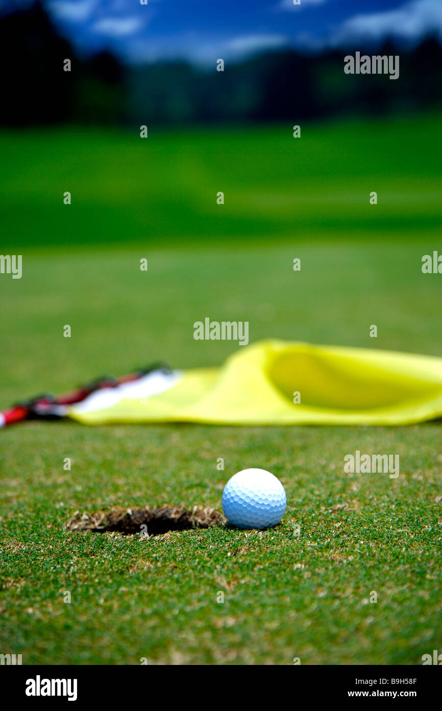 Golfball am Rand der Bohrung gefallene Flagge Stockfoto