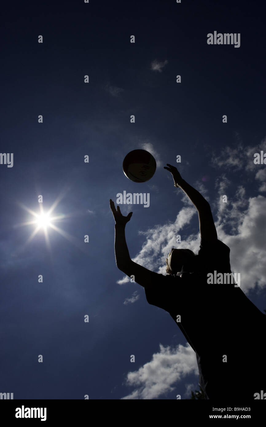 junge Gegenlicht Ballspiele außerhalb Himmel Sonne Stockfoto