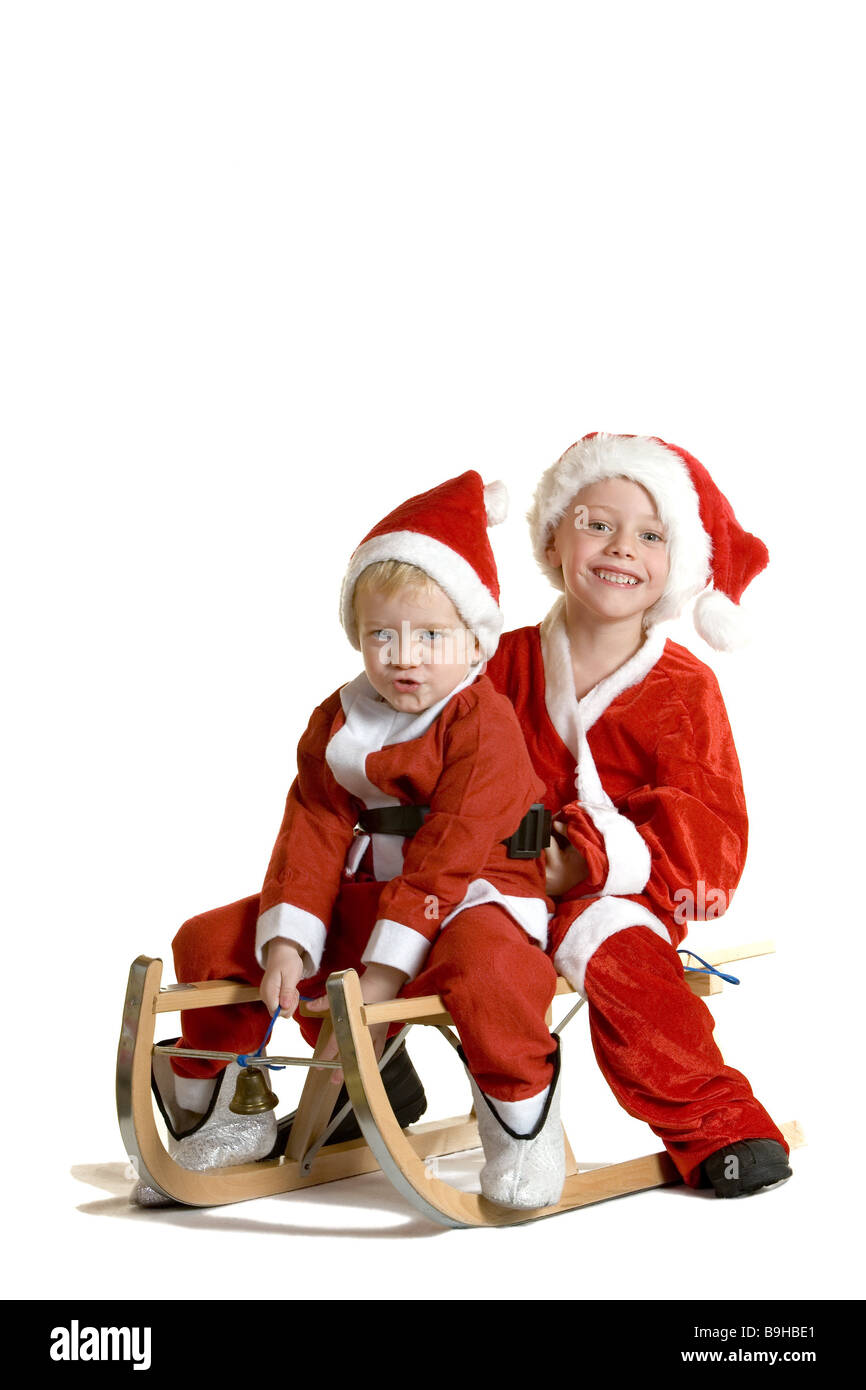 Junge Weihnachtsmann Outfit Pferdeschlitten Kinder Geschwister zwei Weihnachten sitzen glücklich kleiner Scherz fröhlich Freude niedlich Lächeln Stockfoto
