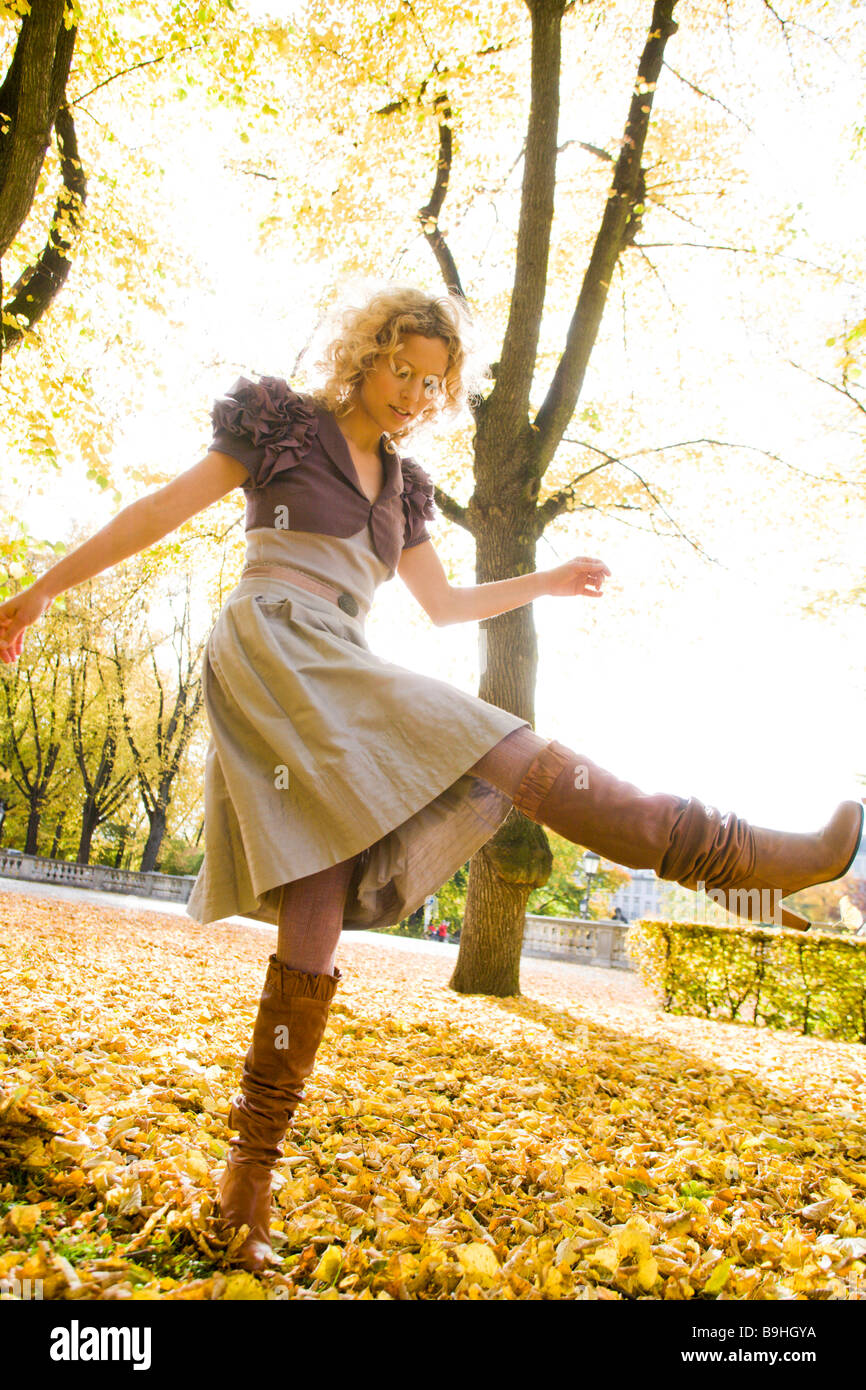 Frau tanzt in Haufen von Blättern Stockfoto