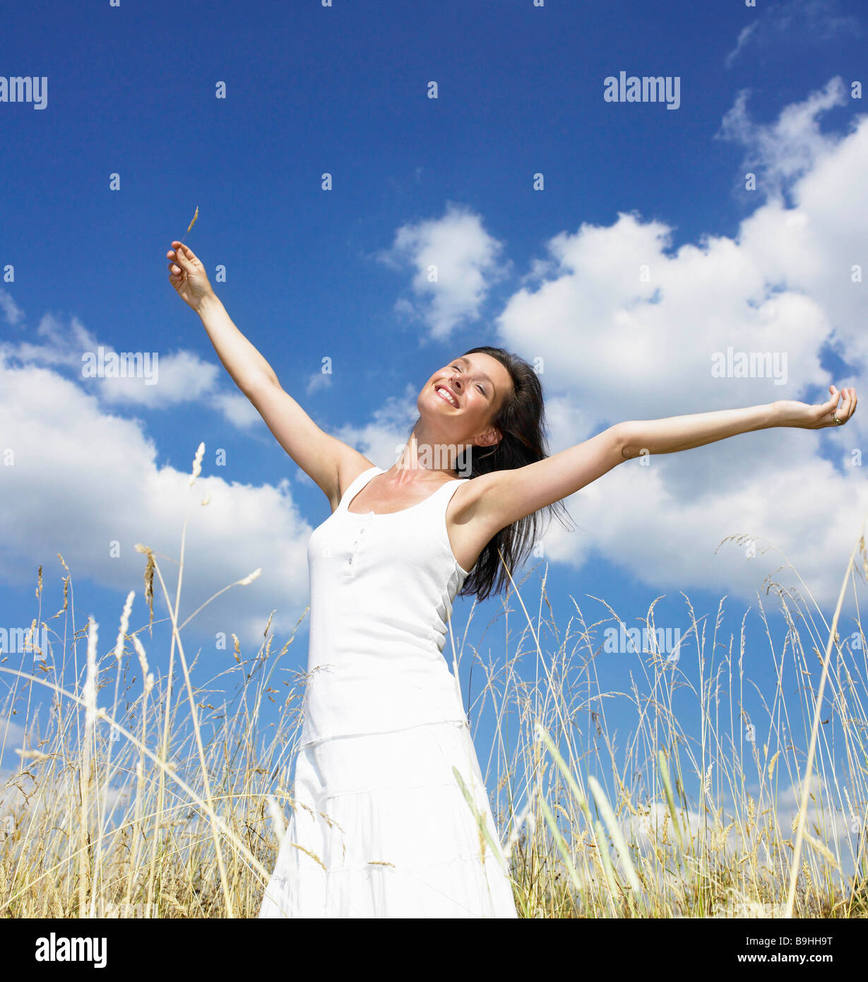 Frau in einem Feld, die Sonne genießen Stockfoto
