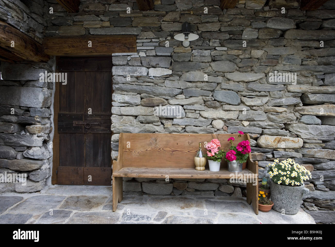 Schweiz Tessin Valle Verzasca Gerra Hauswand Bank Geranie-Töpfe Balkonblumen Bank Bewässerung Bewässerungssystem Blumen Stockfoto