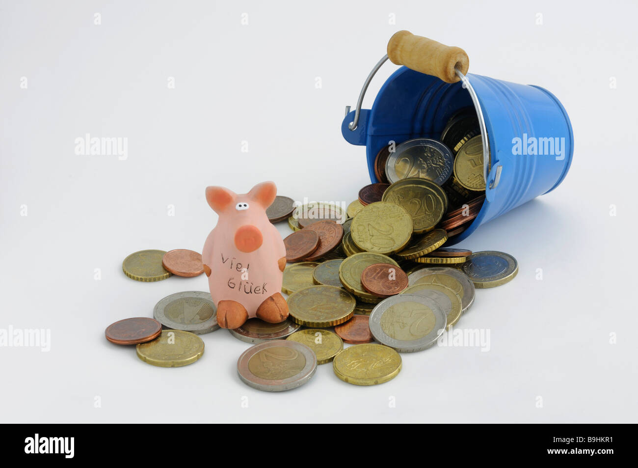 Eimer mit Euro-Münzen und ein Glücksschwein umgekippt Stockfoto