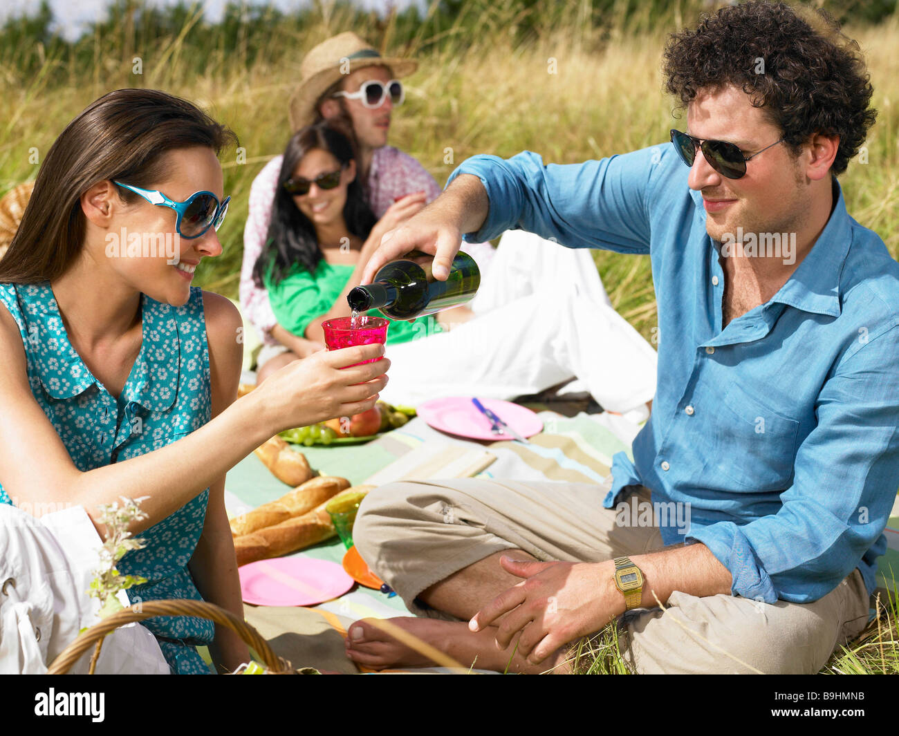 Freunde mit einem Picknick in einem Feld Stockfoto