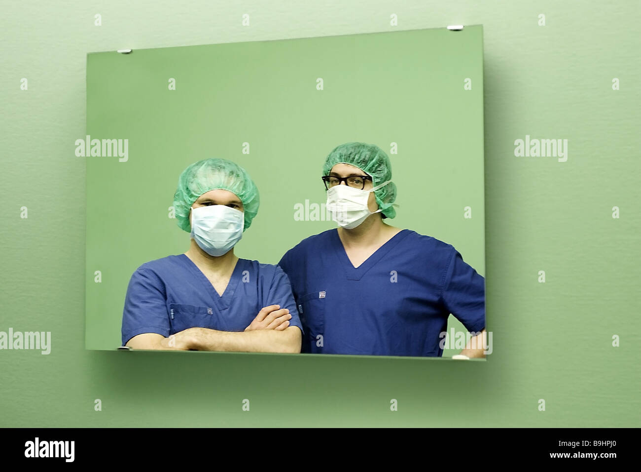 OP-Ärzte-Wandspiegel Reflexion Porträt Menschen Ärzte Ärzte OP-Team Peelings Gesicht Maske Chirurgen Medizin Mannbetrieb Stockfoto
