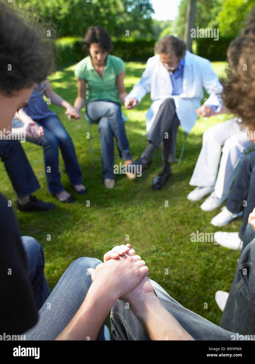 Kreis von Menschen in der Reha, Hand in Hand Stockfoto