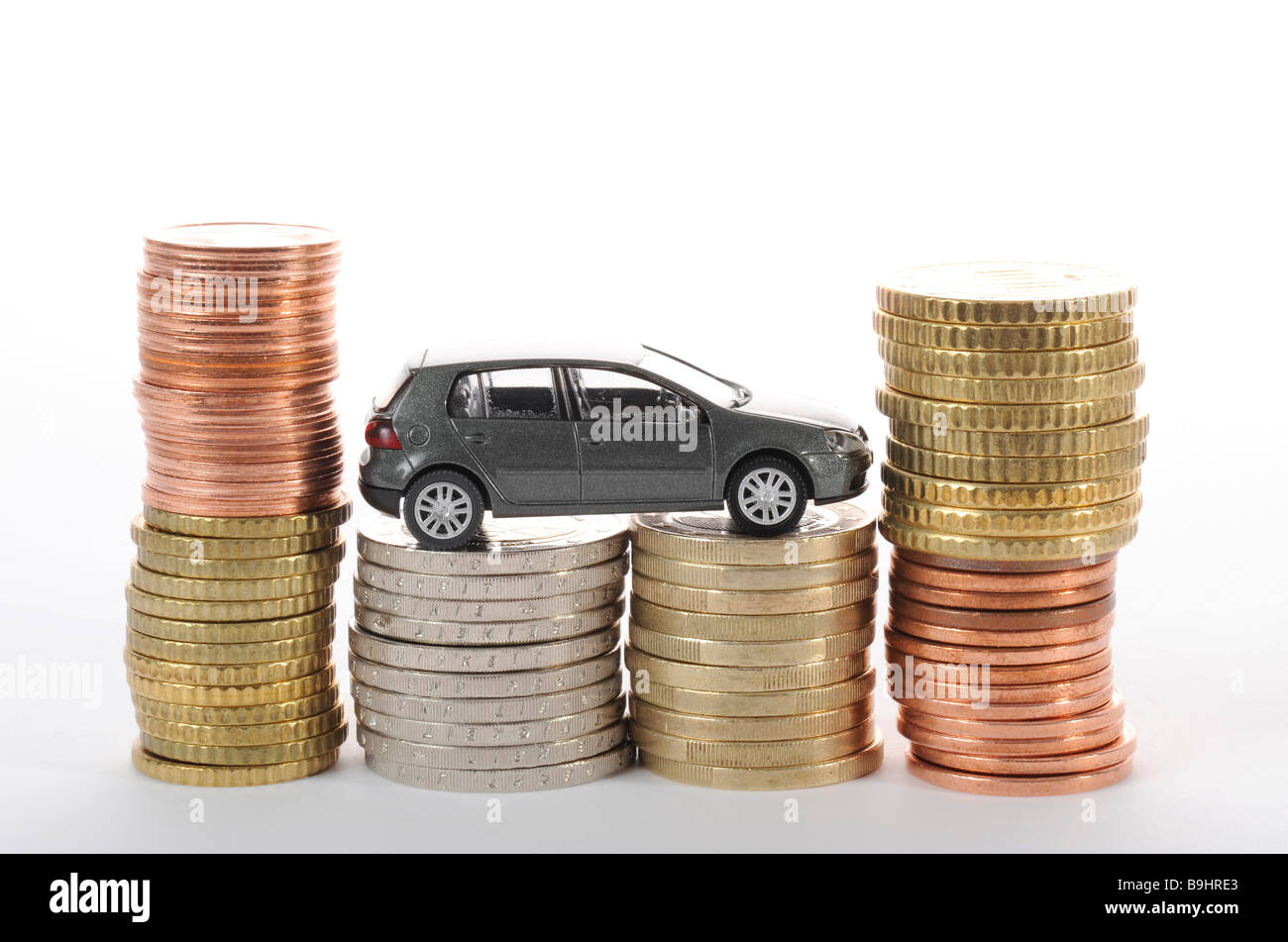 Miniatur-Auto auf Münzen, symbolisch für Pendlerpauschale, Kilometergeld, Wagenpflege Stockfoto
