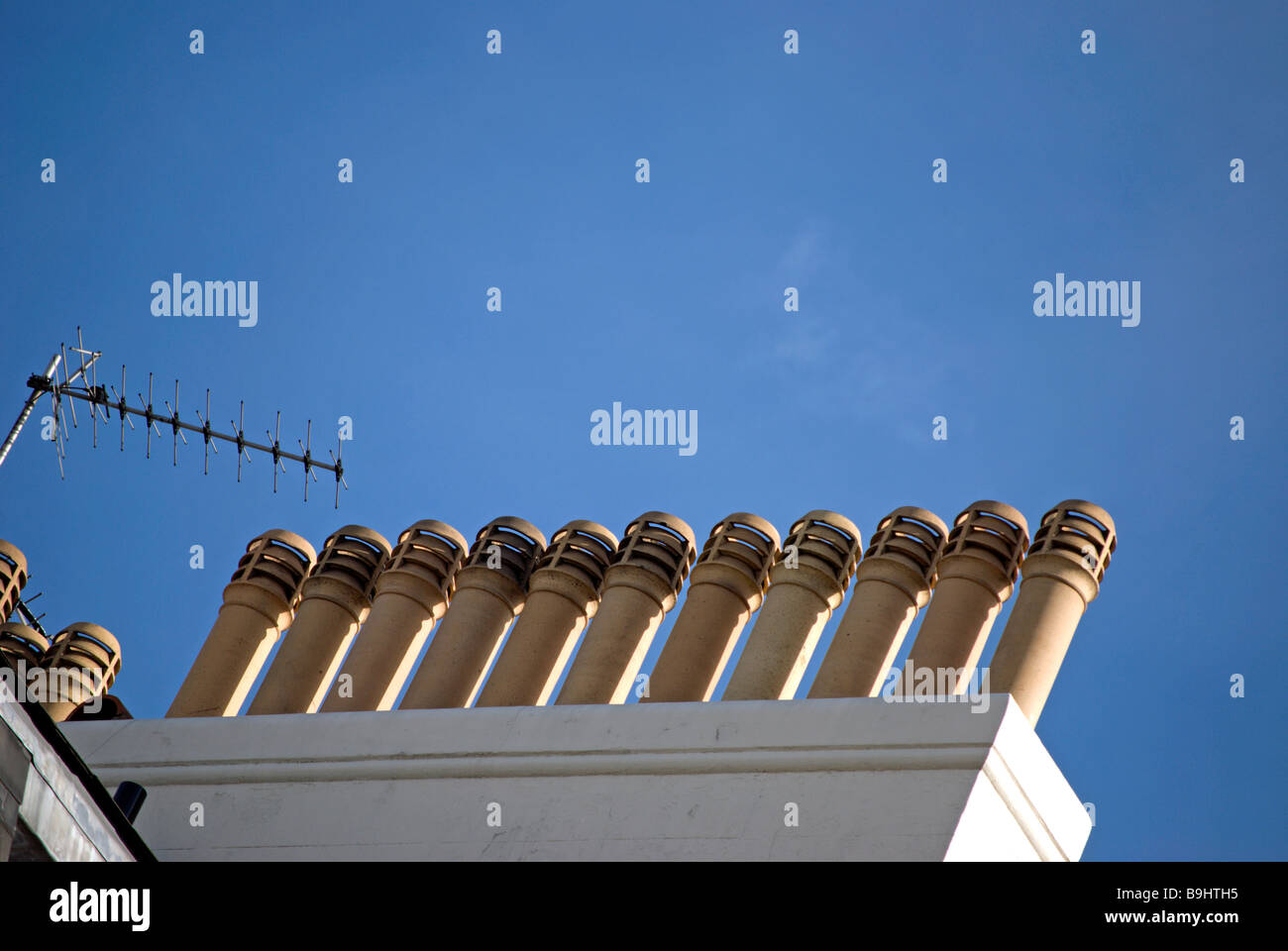 Reihe von Schornsteinen vor einem blauen Himmel auf ein Wohnhaus in der Nähe von Belgrave Square in London, england Stockfoto