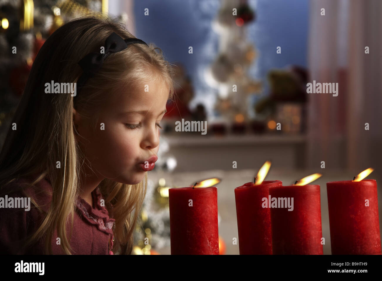 Mädchen-Kerzen ausblasen Porträt an der Seite Menschen Kind Kind-Porträt 5-7 Jahre blonde langhaarige Mund Lippen Advent Stockfoto
